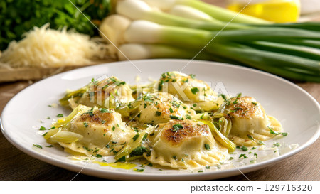 Pan-fried ravioli with a golden crust, tossed with thinly sliced leeks, garnished with fresh parsley. Clean white plate captures, elegant Italian meal, perfect for food blogs, menus, culinary projects 129716320