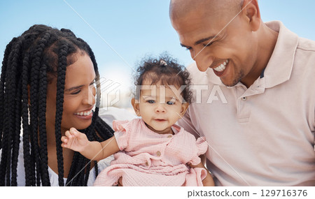 Mother, father and baby in nature as a happy family on summer holiday vacation in Rio de Janeiro, Brazil. Relaxed father, mom and cute newborn girl love enjoying fun quality time or bonding at beach 129716376