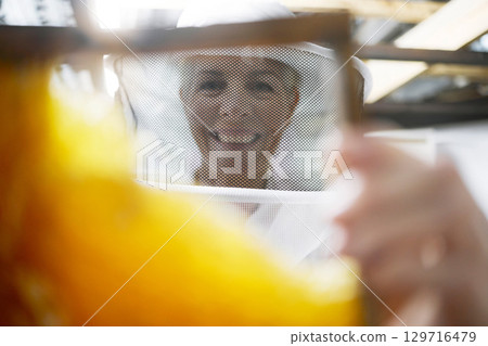 Woman beekeeper, portrait and bee hive for honey production, eco friendly farming and sustainability. Happy senior face, beekeeping and frame to process sweet honeycomb, manufacturing and bees growth Woman beekeeper, portrait and bee hive for honey production, eco friendly farming and sustainability. Happy senior face, beekeeping and frame to process sweet honeycomb, manufacturing and bees growth 129716479