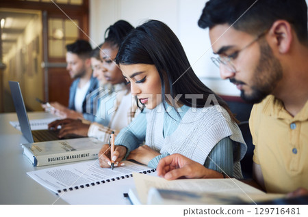 University, education and students studying for exam, test or assignment in the library on campus. Scholarship, knowledge and young friends learning in college class with technology and information. 129716481