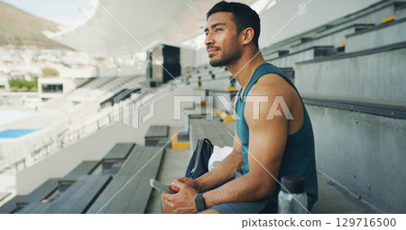Thinking, athlete and man with smartphone, stadium or sportswear for fitness, calm or workout break. Outdoor, runner and planning for marathon, wellness and person with mobile, wonder or reflection 129716500
