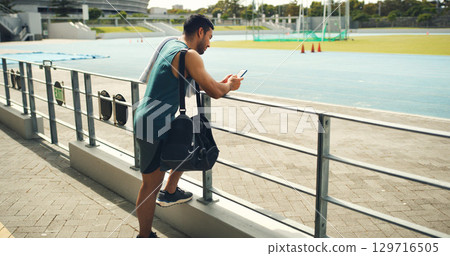 Athlete, man and reading with phone at stadium for social media, fitness app and event agenda. Male person, rest and mobile for texting contact, sports progress results and information for tournament 129716505