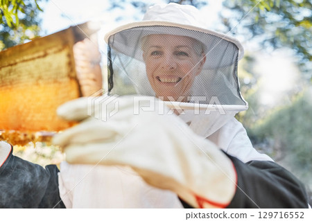 Beekeeping, farm and woman beekeeper in the honey production industry working on sustainable field. Eco friendly, farming and female farmer busy with natural bee honeycomb process in agro environment 129716552