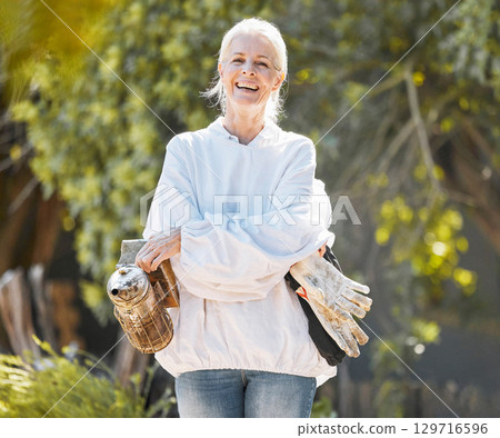 Beekeeper woman, portrait and smile with protective suit, happy and work outdoor in agriculture. Senior bee farmer, happy and beekeeping ppe at farm, backyard or bee bellows for honey production 129716596