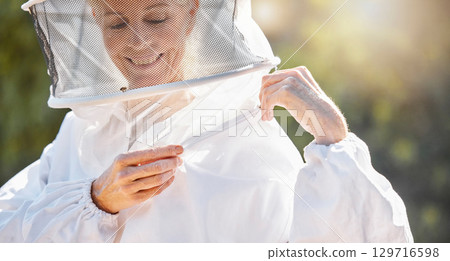 Bee farming, woman and beekeeper with suit for safety, ready to work with honey, production and ppe for protection. Natural product, agriculture and bees with happy farmer and beekeeping outdoor. 129716598