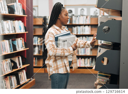 Books, education or black woman in a library to search for knowledge by bookshelf on a school or college campus. Focused, studying or university student learning for a scholarship or better future Books, education or black woman in a library to search for knowledge by bookshelf on a school or college campus. Focused, studying or university student learning for a scholarship or better future 129716614