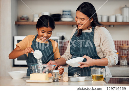 Mother, girl and learning cooking in kitchen, bonding or having fun. Love, care and happy mama teaching kid chef baking, mixing flour in bowl and smiling while enjoying quality time together in house 129716669