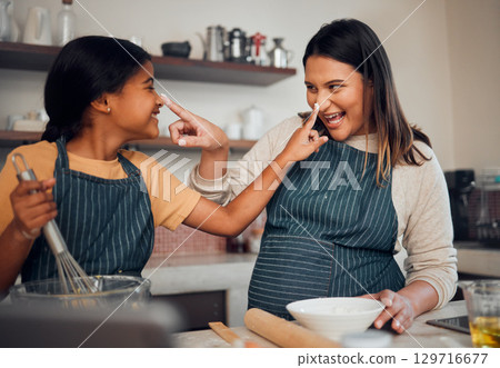 Mother, girl and cooking while playing with flour, having fun or bonding. Learning, education and happy child chef with caring mom baking pastry, smiling and enjoying time together with dough on nose Mother, girl and cooking while playing with flour, having fun or bonding. Learning, education and happy child chef with caring mom baking pastry, smiling and enjoying time together with dough on nose 129716677