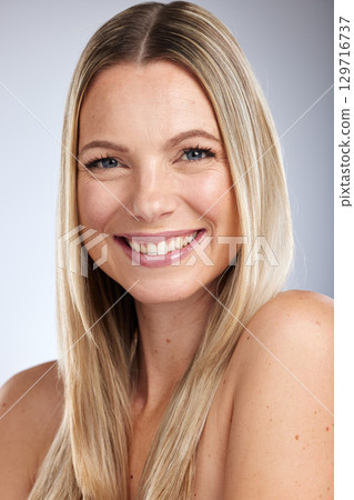 Portrait, beauty and skincare with a model woman in studio on a gray background for natural treatment. Face, happy and smile with an attractive young female posing to promote a cosmetic product Portrait, beauty and skincare with a model woman in studio on a gray background for natural treatment. Face, happy and smile with an attractive young female posing to promote a cosmetic product 129716737