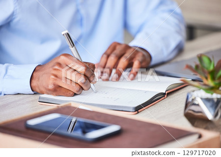 Business, man and writing in a notebook to plan a corporate strategy and ideas for development. Book, write and hand on paper to develop a professional idea while brainstorming at his desk Business, man and writing in a notebook to plan a corporate strategy and ideas for development. Book, write and hand on paper to develop a professional idea while brainstorming at his desk 129717020