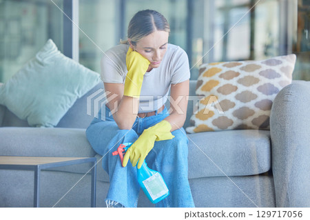 Tired, thinking and woman cleaning home on break with fatigue, unhappy and frustrated with routine. Spring cleaning, burnout and exhausted girl holding detergent spray thoughtful on lounge sofa. Tired, thinking and woman cleaning home on break with fatigue, unhappy and frustrated with routine. Spring cleaning, burnout and exhausted girl holding detergent spray thoughtful on lounge sofa. 129717056