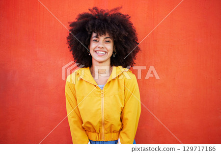 Portrait of happy woman with natural hairstyle on red background, headshot of model and red copy space. Confident young person with smile expression, curly hair and aesthetic fashion on studio wall Portrait of happy woman with natural hairstyle on red background, headshot of model and red copy space. Confident young person with smile expression, curly hair and aesthetic fashion on studio wall 129717186
