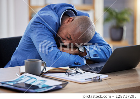 Tired, professional burnout and black man sleep at desk, mental health and depression with sick businessman, corporate and exhausted. Sleeping, work and insomnia, business, fatigue and rest in office 129717293