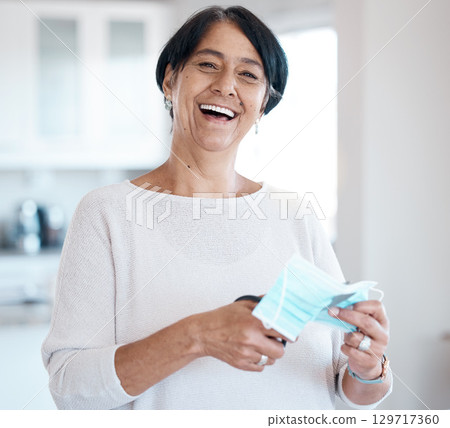 Senior woman, portrait and covid face mask with a scissor in hands for cutting while happy about freedom. Face of old person in house with smile for change, vaccine and corona recovery in retirement 129717360