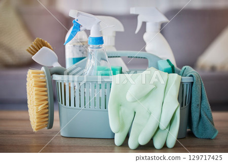 Cleaning, products and basket on table in home living room for spring cleaning. Hygiene, cleaning supplies and housekeeping equipment for disinfecting, sanitizing or removing germs, bacteria or dust. 129717425