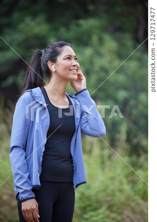 Fitness, wellness and woman in forest with earphones listening to music, audio and radio for workout. Sports, healthy lifestyle and girl in outdoor park for marathon training, running and exercise Fitness, wellness and woman in forest with earphones listening to music, audio and radio for workout. Sports, healthy lifestyle and girl in outdoor park for marathon training, running and exercise 129717477