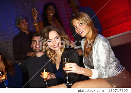 Friends, party and champagne celebration in nightclub for new years, happy birthday or social event together for nightlife. Happy friendship, clubbing and celebrate with alcohol drink in disco club 129717505