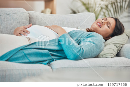 Pregnant, pain and woman in labor with stomach pain and childbirth at family home, new mom and pregnancy emergency. Health, prenatal care and medical, breathing and abdomen ache with pregnant woman. 129717566
