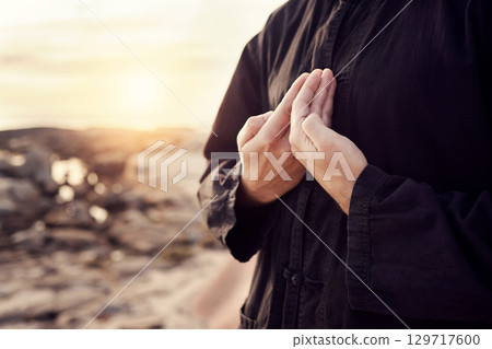 Man, hands or tai chi on sunset beach for relax exercise, workout or training for mental health, chakra balance or mind wellness. Zoom, person or martial arts by sea, ocean or nature water at sunrise 129717600