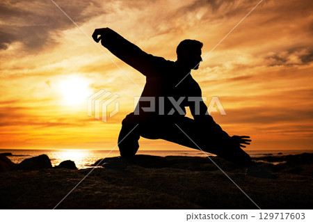 Karate man, silhouette and tai chi with sunset sky on beach horizon for martial arts, taekwondo or fight exercise, training or practice. Art deco of athlete at sea for nature workout and fitness Karate man, silhouette and tai chi with sunset sky on beach horizon for martial arts, taekwondo or fight exercise, training or practice. Art deco of athlete at sea for nature workout and fitness 129717603