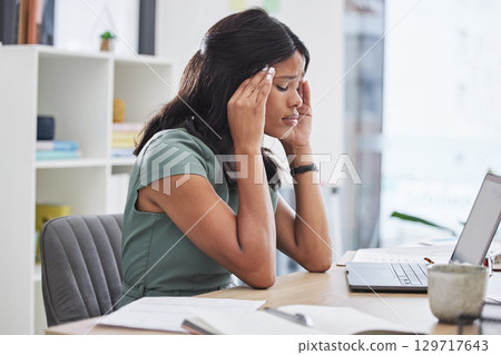 Black woman, stress and headache on laptop working at the office suffering from mental health issues. African female employee sitting by computer desk in pain, burnout or anxiety at the workplace 129717643