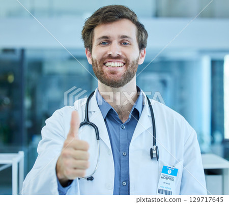 Portrait, doctor and thumbs up for success in hospital, clinic or healthcare facility. Thank you, welcome and hand gesture of confident male medical professional for approval, agreement or support. 129717645