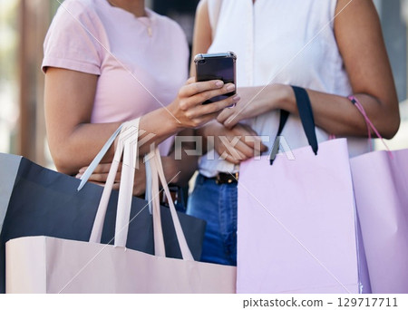 Smartphone, shopping bag and women or friends with website sale, online discount or promotion deal with e commerce, fintech or mobile app. Outdoor, shopping and people hands using phone for ecommerce 129717711