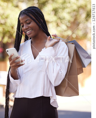 Phone, shopping or black woman on social media in city searching for fashion deals, sales offers or online promotion. Smile, African girl or happy customer with shopping bags typing a discount code Phone, shopping or black woman on social media in city searching for fashion deals, sales offers or online promotion. Smile, African girl or happy customer with shopping bags typing a discount code 129717813