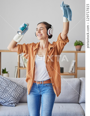 Happy, dance or woman cleaning with music streaming on headphones to relax to radio audio at home. Smile, wellness, or excited cleaner dancing with cloth or spray bottle to wipe dirty dusty bacteria 129717815