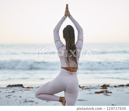 Yoga, fitness and beach workout with a black woman in tree pose for exercise, balance and zen meditation for health and wellness outdoor in nature. Back of female for chakra training for healthy body 129717830