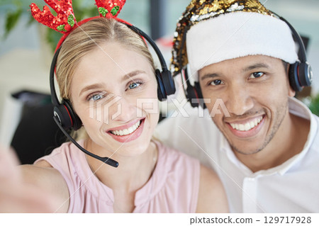 Selfie, christmas and call center with a man and woman consultant team working in customer service. Face, crm and telemarketing with male and female sales colleagues at work in the festive season Selfie, christmas and call center with a man and woman consultant team working in customer service. Face, crm and telemarketing with male and female sales colleagues at work in the festive season 129717928