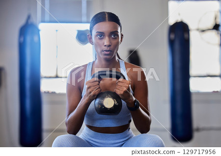 Kettlebell, fitness and training black woman or workout bodybuilder in a gym studio for muscle wellness, body goals and power. Focus, breathing and a strong sports athlete with training gear exercise 129717956