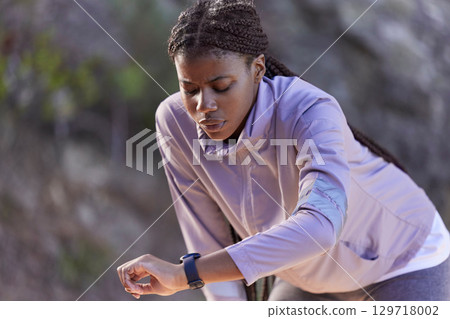 Black woman runner, smartwatch and rest for breathing, heart rate or health while training in summer. Woman, running and healthcare tech for exercise, workout and fitness at nature park in California 129718002