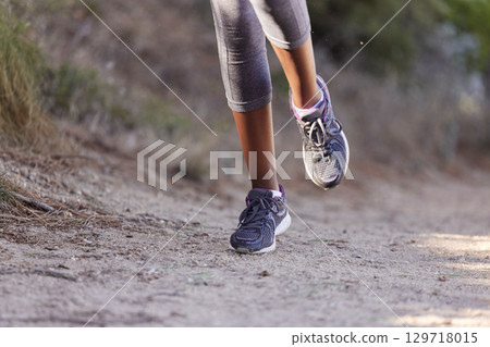 Running, training and shoes of black woman on path of mountain for cardio, workout and exercise. Fitness, health and cardio with girl runner jogging on park trail for endurance, performance and goal Running, training and shoes of black woman on path of mountain for cardio, workout and exercise. Fitness, health and cardio with girl runner jogging on park trail for endurance, performance and goal 129718015