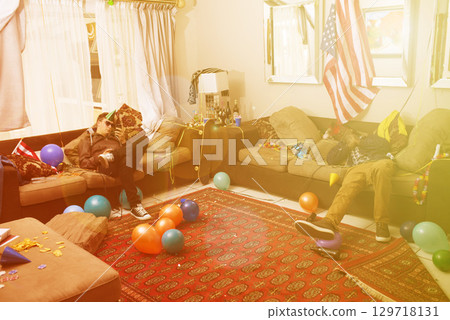 Party, drunk and hangover with a man friends sleeping on a sofa in the living room of a home after a celebration. Birthday, social and alcohol with a male bachelor and friend passed out from drinking Party, drunk and hangover with a man friends sleeping on a sofa in the living room of a home after a celebration. Birthday, social and alcohol with a male bachelor and friend passed out from drinking 129718131