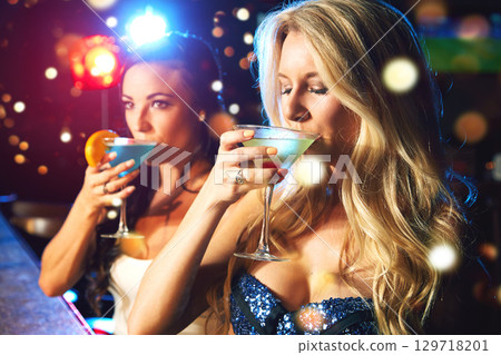 Women, cocktail and drink at party or nightclub, celebrate new year with alcohol drinks, friends and drinking together. Celebration, fun at happy hour with social and holiday event with cocktails. 129718201