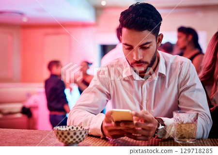 Phone, party and waiting with a man in a nightclub, checking his text message alone while his date is late. Contact, stood up and contact with a male in a club, browsing social media on new year 129718285