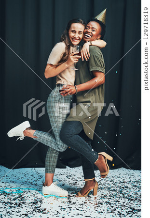 Friends, portrait and hug at New Years eve party with fun, happy women celebrating together. Social, embrace and partying ladies celebrate nightlife with confetti and alchohol drinks on a background 129718319