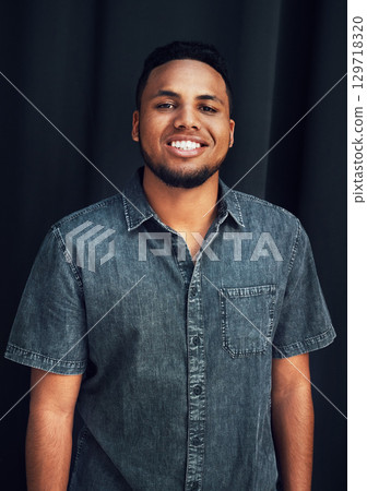Happy portrait, pride and black man in studio for happiness, posing and fashion style against dark black background. Smile, denim and face of an African model with stylish clothes on dark background Happy portrait, pride and black man in studio for happiness, posing and fashion style against dark black background. Smile, denim and face of an African model with stylish clothes on dark background 129718320