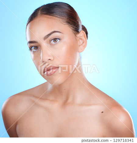 Face, skincare and woman for beauty portrait in studio, cosmetics makeup and luxury wellness. Model, spa facial cleaning and natural skin glow or relax self care dermatology in blue background 129718341