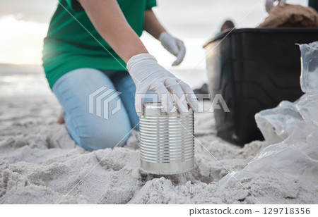 Recycle, volunteer hand cleaning beach and can in sand, picking up dirt at ocean on earth day. Community service, sustainability and environmental charity, people pick up trash for future of planet. 129718356