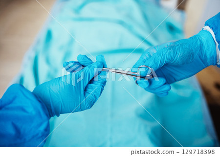 Scissor, hands and surgery for healthcare, medical or emergency room for heart failure procedure. Doctor, nurse and team with equipment in hospital, recovery or diagnosis for patient or staff hygiene 129718398