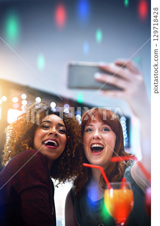 Friends, selfie and women party and holiday celebration with cocktails at new year event and smile in photo, smartphone and happy. Social, celebrate holiday and happiness in picture with alcohol. Friends, selfie and women party and holiday celebration with cocktails at new year event and smile in photo, smartphone and happy. Social, celebrate holiday and happiness in picture with alcohol. 129718428