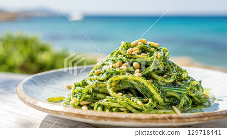 A vibrant and healthy dish of fresh zucchini noodles tossed in a rich, homemade pesto sauce and topped with crunchy pine nuts. This is a light, gluten-free, and refreshing summer meal A vibrant and healthy dish of fresh zucchini noodles tossed in a rich, homemade pesto sauce and topped with crunchy pine nuts. This is a light, gluten-free, and refreshing summer meal 129718441