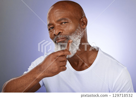 Face, senior man and beard comb in studio isolated on a purple background. Portrait, retirement and hair care of elderly black man holding facial hair product for grooming, fresh hygiene and wellness Face, senior man and beard comb in studio isolated on a purple background. Portrait, retirement and hair care of elderly black man holding facial hair product for grooming, fresh hygiene and wellness 129718532