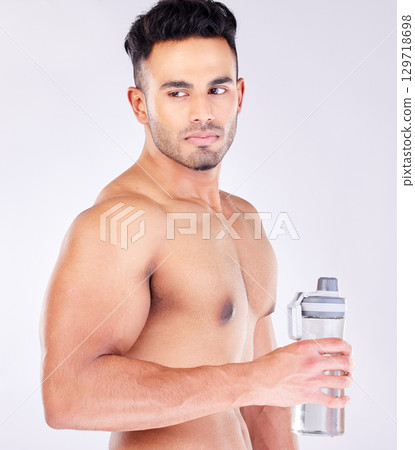 Fit, strong and workout break and water bottle with a man ready to drink water on a grey studio background. Bodybuilder, drinking water and exercise or training break for thirsty hydration Fit, strong and workout break and water bottle with a man ready to drink water on a grey studio background. Bodybuilder, drinking water and exercise or training break for thirsty hydration 129718698
