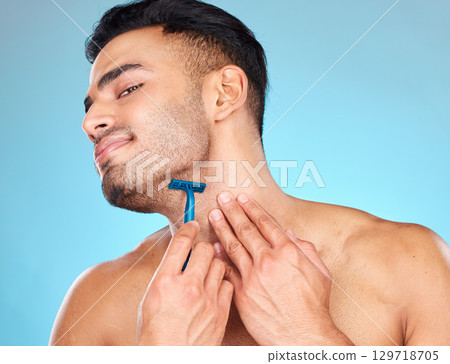 Man shaving, razor and grooming beard or facial hair for self care, skincare and body wellness on blue studio background. Face of indian model with a smile for clean shave, cosmetics and healthy skin Man shaving, razor and grooming beard or facial hair for self care, skincare and body wellness on blue studio background. Face of indian model with a smile for clean shave, cosmetics and healthy skin 129718705
