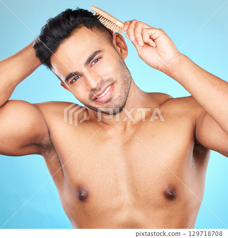 Beauty, hair and brush with portrait of man for grooming, hygiene or self care routine. Salon, hairstyle and treatment with model for cosmetics, brushing and product against blue background in studio Beauty, hair and brush with portrait of man for grooming, hygiene or self care routine. Salon, hairstyle and treatment with model for cosmetics, brushing and product against blue background in studio 129718708