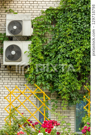 Air conditioners are installed on facade of building. device for comfortable living in hot weather. 129718798