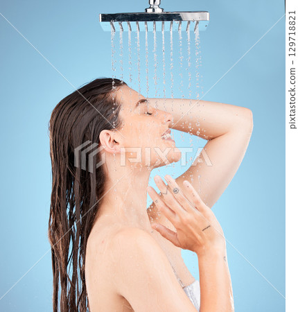 Woman, shower and water mockup for skincare health, showering for clean skin and natural wellness. Healthy beauty model, happy face and advertising healthcare or hygiene on a studio blue background Woman, shower and water mockup for skincare health, showering for clean skin and natural wellness. Healthy beauty model, happy face and advertising healthcare or hygiene on a studio blue background 129718821